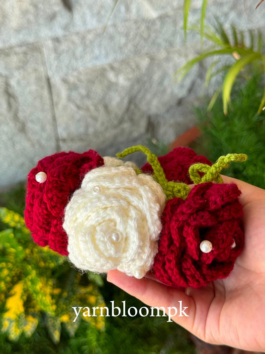 Close-up of handmade crochet flower gajra with maroon and ivory roses